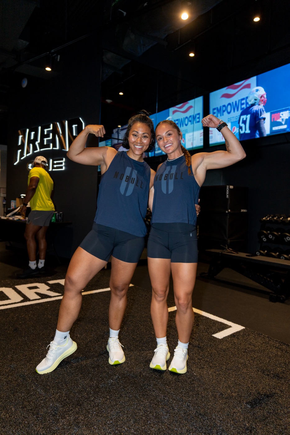 Two League members flexing on the training floor.