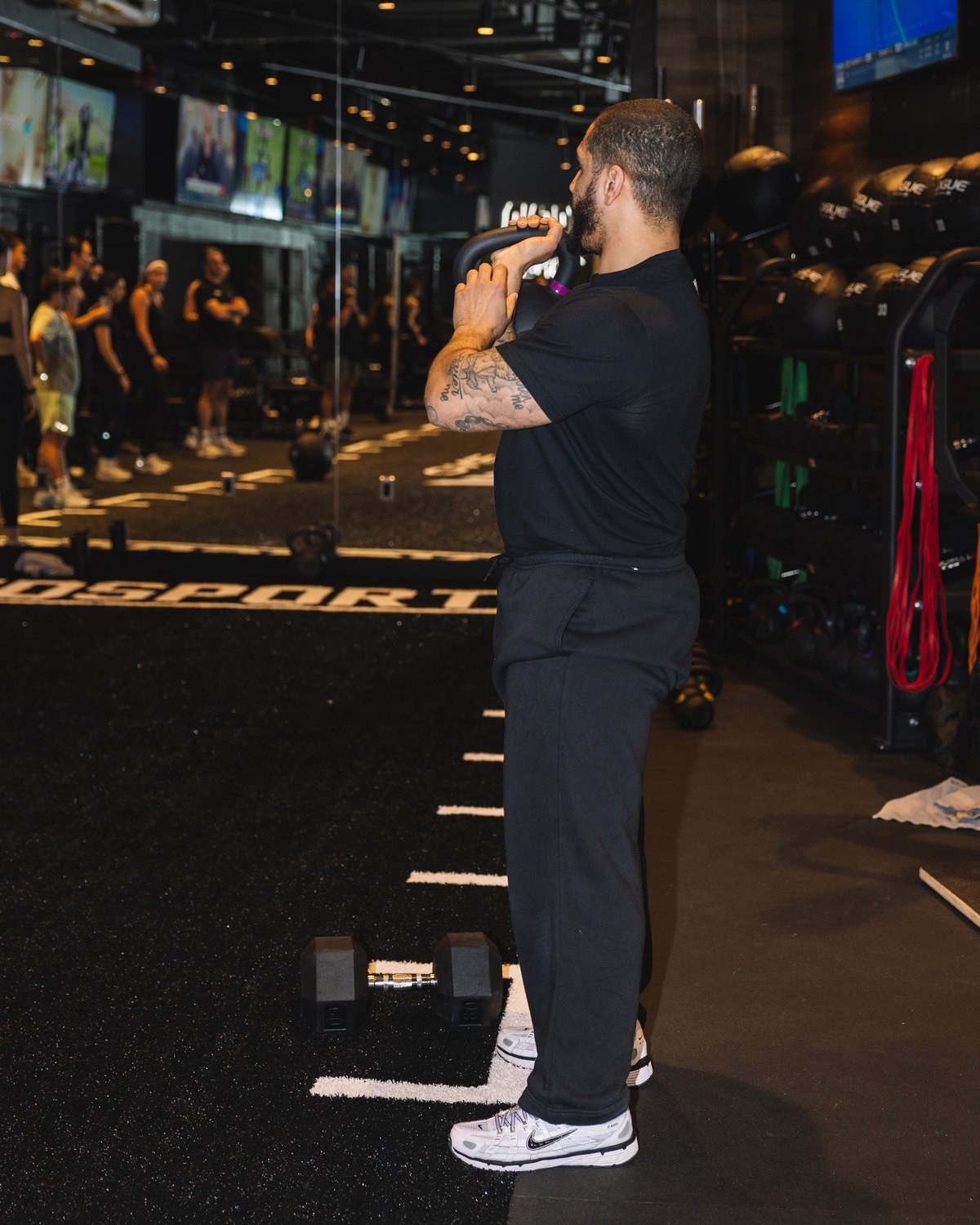 A coach and a client talking on the training floor.